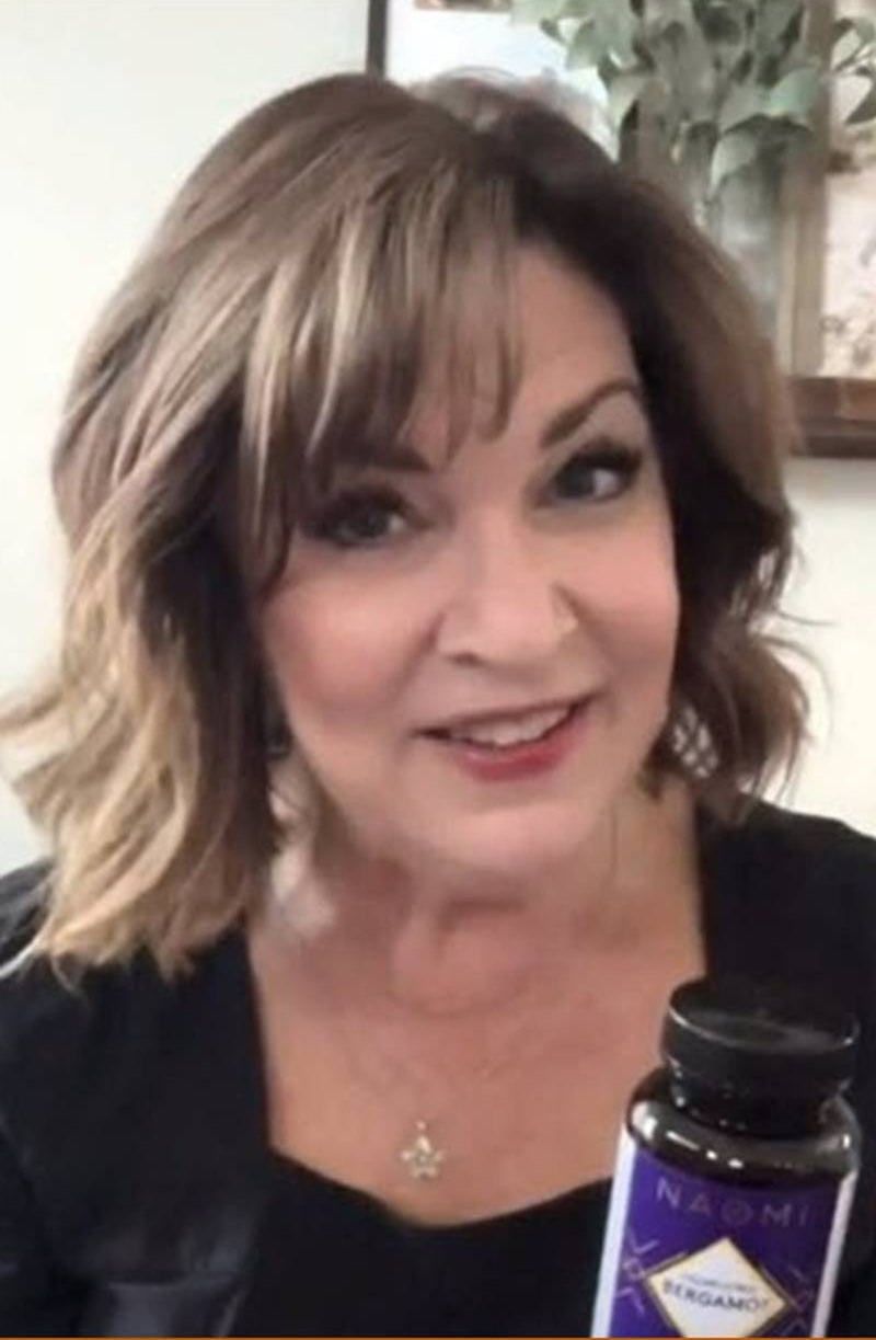 Woman holding a bottle of Naadam supplements with a blurred background